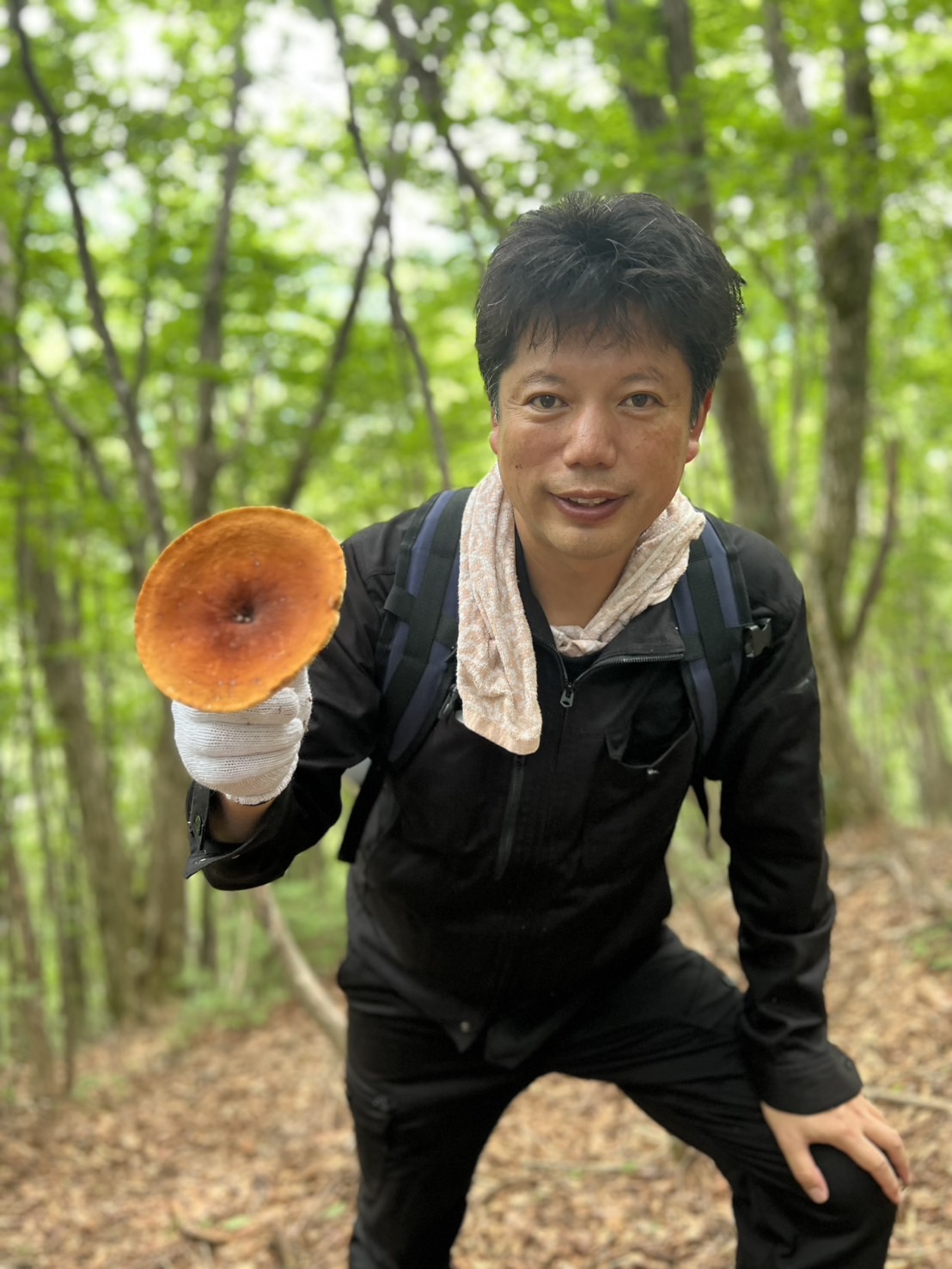 森で野生のきのこを持つ井口智明さん